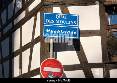 Un cartello bilingue francese / tedesco per il Quai des Moulins / Müehlstade di fronte a un tradizionale edificio in legno, Strasburgo, Alsazia, Francia Foto Stock