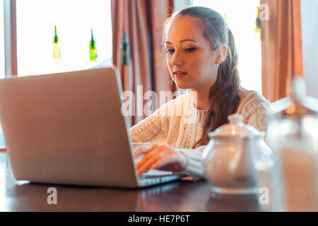 Yong donna un lavoro al computer portatile in cafe Foto Stock