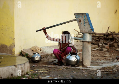 Villaggio indiano ragazza sorridente e installatori borewell per acqua Foto Stock