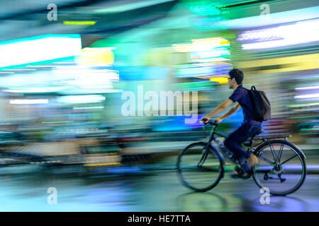 Ciclista sotto la pioggia in Ho Chi Minh Vietnam Foto Stock