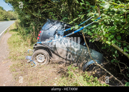 Smart auto abbandonate nella siepe di paese Lane, Regno Unito Foto Stock