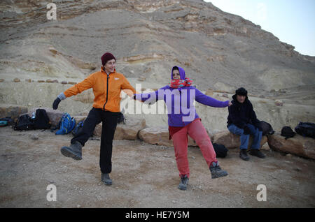 Due donne di congelamento, escursionisti, tutti vestiti con la fredda mattina stanno facendo il tai chi all'alba per il riscaldamento prima di una faticosa escursione Foto Stock