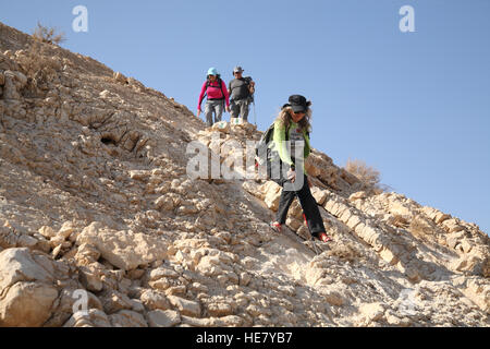 Un senior citizen donna escursionista scende con attenzione un molto ripido pendio roccioso dal Monte Massor usando un escursionismo stick per evitare la caduta di Foto Stock