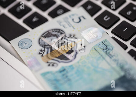 Il nuovo polimero 2016 cinque pound nota sulla tastiera di un computer Foto Stock