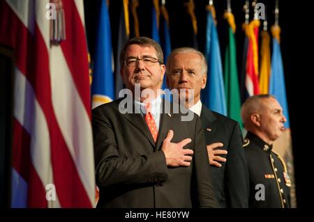 Stati Uniti Vice presidente Joe Biden e il Segretario della Difesa Ashton Carter stand per l'Inno Nazionale durante una cerimonia di transizione per miniera agguato resistente veicoli protetti al Pentagono Ottobre 1, 2012 a Washington, DC. La cerimonia segna la transizione del programma MRAP dal Marine Corps all'esercito. Foto Stock