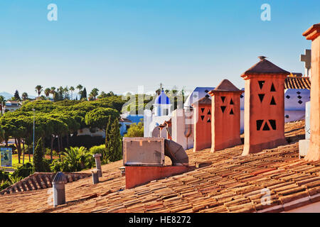 Orange tegole del tetto con camini sotto il cielo blu Foto Stock