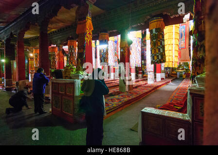 Lhasa: Monastero di Drepung; pilastri nel gruppo principale hall Tshogchen Dukhang; pregare la gente, Tibet, Cina Foto Stock