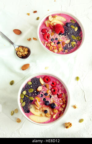 Ciotola frullato con frutti di bosco freschi, noci, semi e cereali fatti in casa per una sana prima colazione Foto Stock