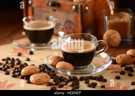 Caffè espresso italiano in tazza di vetro con amaretti intorno Foto Stock