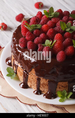 Torta al cioccolato con lamponi freschi close-up su una piastra verticale. Foto Stock