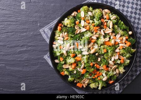 Cibo sano: Insalata di broccoli con arachidi e carote close-up su una piastra nera. vista orizzontale dal di sopra Foto Stock
