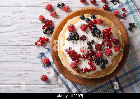 In casa pila di crepes con frutti di bosco e crema di close-up sul tavolo. vista orizzontale dal di sopra Foto Stock