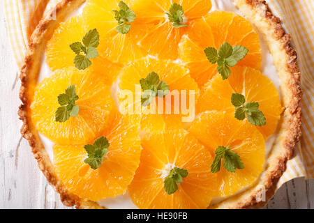 Orange crostata con una deliziosa crema di latte e menta macro sul tavolo. vista orizzontale dal di sopra Foto Stock