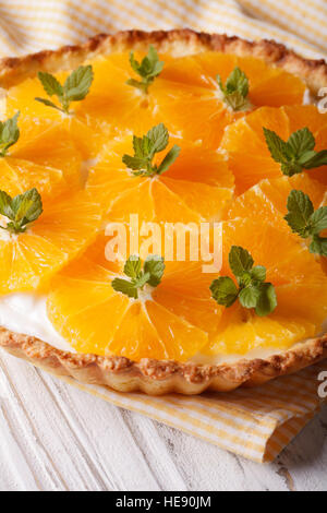 Orange crostata con una deliziosa crema di latte e menta vicino sul piano verticale. Foto Stock