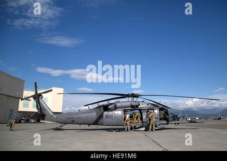 Avieri assegnato alla 210th Rescue Squadron, Alaska Air National Guard, ingranaggio di carico su un HH-60G Pave Hawk elicottero prima di condurre operazioni di volo su base comune Elmendorf-Richardson, Alaska, 23 luglio, 2015. Il 210th squadrone di salvataggio di emergenza fornisce servizi di salvataggio per i cittadini dell Alaska oltre a corsi di formazione per il tempo di guerra contro la ricerca e il salvataggio delle missioni. Alejandro Pena) Foto Stock