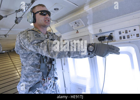 Sgt. 1. Classe Garret Brunton, sede e Sede Società, 1° Battaglione (airborne), 501Reggimento di Fanteria, impartisce il comando per la porta lato personale per stand up come soldati preparare per uscire da una C-23 Sherpa aeromobile su malamute nella zona di caduta, 12 giugno 2013. Quasi 300 soldati saltato a 1.500 piedi con tanto di combattimento completa attrezzatura e 'Hollywood', o di assenza di carico, da aeromobili pilotati dai membri del primo battaglione, 207th reggimento di aviazione, Alaska Esercito nazionale di protezione. In grado di aumentare la velocità, altitudine più elevata e la possibilità di coprire distanze più lunghe di elicotteri militari, il C-23 c Foto Stock