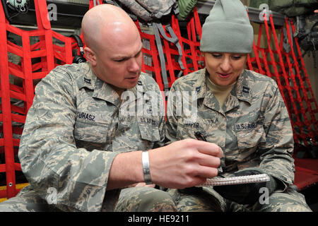 Nevada Air National Guard Capt. Jason Yuhasz, Public Affairs Officer per la 152Airlift Wing e U.S. Air Force Reserve Capt. Meg Harper dal 4 Lotta contro lo squadrone della fotocamera, marzo riserva d'aria di base, California, pianificare le foto e il video la copertura per Allied Forge prima del decollo in un C-130 Hercules aeromobile da San Giovanni, Terranova in rotta verso la Corsica e la Francia il 24 maggio 2014, a sostegno degli alleati per la Forge 2014. Questo esercizio ha portato da parte del governo degli STATI UNITI Esercito ottantaduesima Airborne Division in congiunzione con il 152e 165Air National Guard Airlift Ali, è il primo esercizio di interoperabilità progettato per e Foto Stock