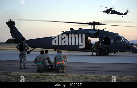 Stati Uniti Air Force aviatori da 355Medical Group attendere per caricare una vittima di un aereo simulato crash durante l'angelo Thunder presso Davis-Monthan Air Force Base, Ariz., 13 aprile 2013. Angelo Thunder fornisce personale di recupero e di lottare contro la ricerca e il salvataggio della formazione per il personale di volo di combattimento, pararescuemen, intelligenza personale, responsabili di battaglia e di ricerca comune e centro di salvataggio personale. Senior Airman Timothy Moore Foto Stock