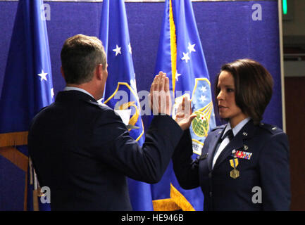 Primo Lt. Iris Morales, servizio medico Corps officer e ex riserva aria centro del personale del centro di contatto sottufficiale, viene somministrato il giuramento di ufficio da Col. Pat Hayes, forza totale centro di servizio direttore, durante la messa in funzione di una cerimonia di premiazione che si terrà a gennaio 30, 2015, su Buckley Air Force Base, Colo. Tech. Sgt. Rob Hazelett) Foto Stock