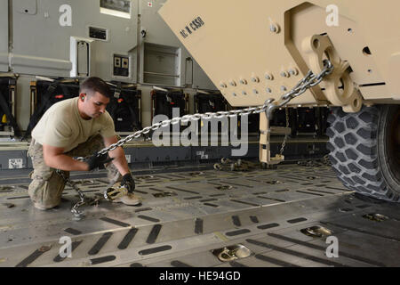 Stati Uniti Air Force Staff Sgt. Ruben Montes, un trasporto aereo artigiano assegnato alla 455th Expeditionary porta antenna squadrone distacco 1, utilizza le catene per bloccare una pesante Mobilità Estesa Tactical carrello nel posto a bordo di una C-17 Globemaster III mentre a Mazar-e Sharif, Afghanistan, Giugno 24, 2014. Come parte della missione retrograda, PAE Det 1 è responsabile per il controllo e il caricamento di merci e veicoli in partenza a Mazar-e Sharif. Montes, nativo di Worthington, Ohio, viene distribuita da 375 disponibilità logistica Squadron, Scott Air Force Base, Ill. Master Sgt. Cohen A. Giovani Foto Stock