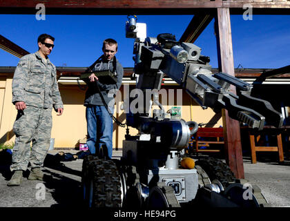 (Da sinistra) U.S. Vigore Airman 1. Classe Taylor Tomkins, 31 Ingegnere Civile squadrone di materiale esplosivo apprendista, orologi Jaiden Raymond, Aviano studente, azionare un F6A robot, Aprile 2, 2015, presso la base aerea di Aviano, Italia. Durante la sua visita al 31 CES EOD volo, Raymond è stata data la possibilità di operare le apparecchiature utilizzate da EOD avieri. Senior Airman Areca T. WILSON Foto Stock