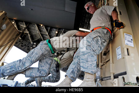 U.S aviatori assegnati al 386Expeditionary disponibilità logistica squadrone porta antenna spostare una paletta di carico su un C-17 Globemaster III in un riservate air base nel sud-ovest Asia, nov. 3, 2010. Il porta antenna aviatori ispezionati e pallettizzato tutte le merci prima della spedizione, da cibo e acqua per le munizioni e il materiale rotabile. Senior Airman Laura Turner Foto Stock