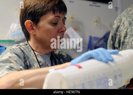 Stati Uniti Air Force Il Mag. Cheryl Lockhart, 455th Expeditionary Medical Group/Task Force Medical Est, imposta le apparecchiature per un paziente dopo la chirurgia presso il Craig Teatro comune ospedale, Bagram Airfield, Afghanistan, 5 maggio. Lockhart è distribuito da Travis Air Force Base in California, ed è da Buffalo, N.Y. Foto Stock