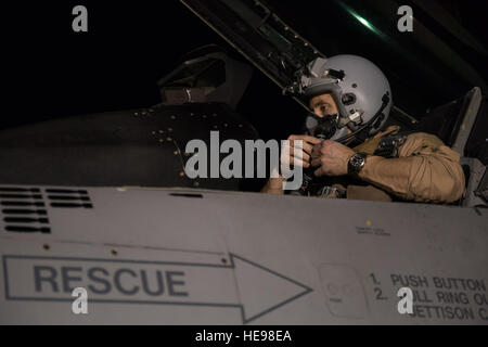 Il cap. Jay Doerfler, 421st Expeditionary Fighter Squadron pilota, mette sul suo casco in un F-16 Fighting Falcon prima di uscire su un volo per superare 1000 combattere ore di volo in Afghanistan a Bagram Airfield, Afghanistan, Aprile 7, 2016. Doerfler ha volato due diversi aeromobili, la MC-12 e F-16, in più di 200 missioni di combattimento da Kandahar e aerodromi Bagram durante più distribuzioni. Doerfler passerà a F-35 Lightning II dopo il suo tempo in Afghanistan. Tech. Sgt. Robert Cloys) Foto Stock