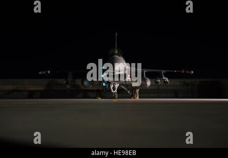 Il cap. Jay Doerfler, 421st Expeditionary Fighter Squadron pilota, attende come munizioni su di un F-16 Fighting Falcon sono ispezionati durante la fine della pista controlli prima di uscire su un volo per superare 1000 combattere ore di volo in Afghanistan a Bagram Airfield, Afghanistan, Aprile 7, 2016. Doerfler ha volato due diversi aeromobili, la MC-12 e F-16, in più di 200 missioni di combattimento da Kandahar e aerodromi Bagram durante più distribuzioni. Doerfler passerà a F-35 Lightning II dopo il suo tempo in Afghanistan. Tech. Sgt. Robert Cloys) Foto Stock