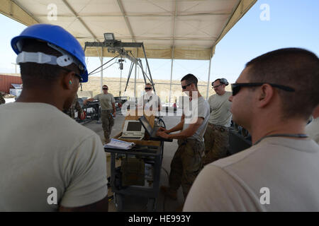 Stati Uniti Air Force aviatori assegnati alla 455th manutenzione Expeditionary Squadron si radunano insieme per rivedere le procedure di sicurezza prima di costruire 10 GBU-38 bombe di Bagram Air Field, Afghanistan Agosto 26, 2014. Il GBU-38 è una parte essenziale del sistema di armi di un F-16C Fighting Falcon. Il distribuito aviatori sono un esempio di forza totale integrazione; il aviatori sono compresi di servizio attivo e riservisti da Whiteman Air Force Base e aria guardie nazionali da Alabama e New Jersey. Foto Stock