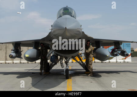 Stati Uniti Avieri assegnato alla 455th Expeditionary Manutenzione aeromobili squadrone eseguire post controlli di volo mentre il Brig. Gen. Mark D. Kelly, 455th Air Expeditionary Wing Commander, si prepara a uscire da un F-16 Fighting Falcon aeromobile dopo il suo ultimo volo come il 455th AEW commander a Bagram Air Field, Afghanistan, 28 giugno 2015 l'ultimo volo è una tradizione di aviazione in cui equipaggi soci, dopo il completamento del loro ultimo volo con l'ala, o 'fini volo,' sono soddisfatte e alloggiata in giù con l'acqua. Tech. Sgt. Giuseppe Swafford Foto Stock