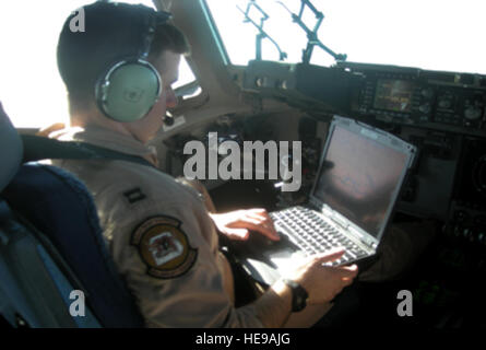 Il cap. James Sprys opera Missione Index battenti software su una mobilità in aria la missione di comando computer laptop. Utilizza MIF airborne la soluzione software in pozzetto, consentendo a personale di volo per volare ad altitudini ottimali e airspeeds per le attuali condizioni di volo, minimizzando in tal modo il tempo di volo e di combustione del carburante e riducendo i costi operativi. Capitano Sprys è un sesto Airlift Squadron C-17 Globemaster III comandante. Foto Stock