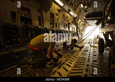 Avieri dal 8 Expeditionary Aria Mobilità Squadron sicuro di un motore aeronautico dentro una C-17 Globemaster III qui 25 aprile 2012. Il personale Sgt. Nathanael Callon)(rilasciato) Foto Stock