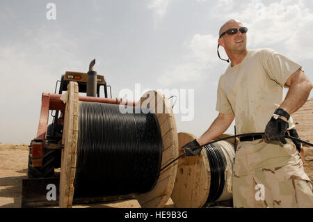 Ali Air Base, Iraq - Senior Airman Matthew Parker, 407 comunicazioni Expeditionary Squadron (ECS), tira il cavo in fibra da una bobina durante un'installazione Luglio 31. I Cani del cavo dalla ECS prevista più di 1200 piedi di fibre e cavi in rame per consentire una nuova unità per spostare in un edificio rinnovato su base. Foto Stock