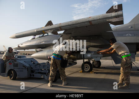 Stati Uniti Avieri dal 455th Expeditionary Manutenzione aeromobili squadrone di volo armi Munizioni di carico su di un F-16 Fighting Falcon aeromobili a Bagram Air Field, Afghanistan, luglio 13, 2015. La F-16 è un multi-ruolo di aerei da combattimento che è estremamente manovrabile e ha dimostrato in aria-aria e aria-terra di combattimento. I membri del triplo nichel sono distribuiti a sostegno del funzionamento della libertà sentinella e della NATO a sostegno deciso la missione. Tech. Sgt. Giuseppe Swafford Foto Stock