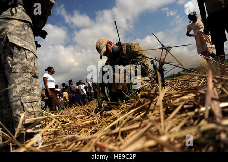 Un U.S. Air Force combat controller prepara per contattare le tattiche speciali operation center mediante la radio mentre si conduce una zona di caduta di indagine a Port-au-Prince, Haiti, Gennaio 24, 2010, durante il funzionamento risposta unitaria. Master Sgt. Jeremy Lock) Foto Stock