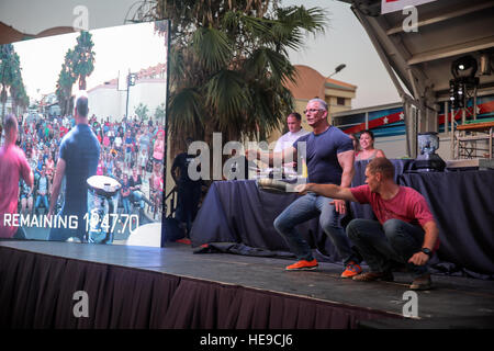 Celebrity Chef Robert Irvine e Lance Cpl. Kai Wendland ha, un ingegnere di combattimento con scopi speciali Air-Ground Marine Task Force Response-Africa crisi, busto alcune mosse sul palco durante uno spettacolo alla Naval Air Station Sigonella, Italia, Luglio 28, 2016. Marines hanno partecipato alla mostra e ha partecipato alle sfide di cottura per tutta la notte. Cpl. Alexander Mitchell/rilasciato) Foto Stock