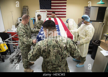 CAMP LEMONNIER, Gibuti - Volontari DA PARTE DEGLI STATI UNITI Navy, Marine Corps, e l'esercito, posizionare una bandiera americana vestito, a temperatura controllata scrigno copertura su simulazioni di resti umani durante un incidente di massa esercizio, Giugno 1, 2016 a Camp Lemonnier, Gibuti. Il personale dei servizi dal 870th Air Expeditionary Squadron, insieme con i volontari da parte degli Stati Uniti Navy, Marines, Esercito e Forze Aeree testato le loro competenze in materia di ricerca e di recupero e affari mortuaria punto di raccolta i processi durante la simulazione di una veicolo-borne improvvisato dispositivo esplosivo risultante di detonazione in due vittime. Il personale Sgt. Tiffany DeNault) Foto Stock