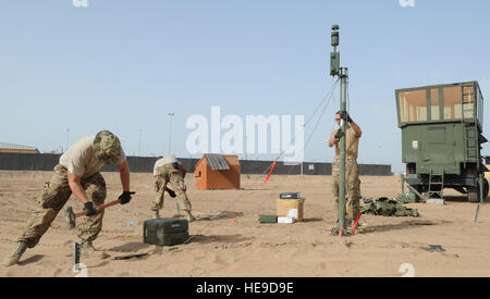 Avieri dal primo combattimento squadrone di comunicazioni drive picchetti nel terreno utilizzando una mazza per stabilizzare una antenna meteo 14 Maggio 2013 durante il set-up della Marina militare dell esercito/Mobile, tipo speciale, aiuto navigazione (UN/MSN-7) a Camp Lemonnier, Gibuti. L'Un'/MSN-7 è un mobile di controllo del traffico aereo torre che può essere trasferito in aereo per qualsiasi località in tutto il mondo quando necessario e aggiunge una nuova funzionalità per la Combined Joint Task Force-Horn dell Africa radar della missione consultiva. Il personale Sgt. Caleb Pierce) Foto Stock