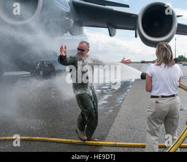 Col. Erik Hansen è ospitato con acqua da sua moglie Susan, dopo il completamento del suo ultimo volo come il 437th Airlift Wing Commander a base comune Charleston - Air Base, S.C., Ottobre 2, 2012. La finale o "fini volo,' è una tradizione di aviazione in cui gli equipaggi degli aeromobili i membri sono soddisfatti dalla loro unità compagni, la famiglia e gli amici e bagnate con acqua. Airman 1. Classe Ashlee Galloway) Foto Stock