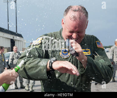 Col. Erik Hansen viene spruzzata con spumante succo d'uva da sua moglie Susan dopo il completamento del suo ultimo volo come il 437th Airlift Wing Commander a base comune Charleston - Air Base, S.C., Ottobre 2, 2012. La finale o "fini volo,' è una tradizione di aviazione in cui gli equipaggi degli aeromobili i membri sono soddisfatti dalla loro unità compagni, la famiglia e gli amici e bagnate con acqua. Airman 1. Classe Ashlee Galloway) Foto Stock