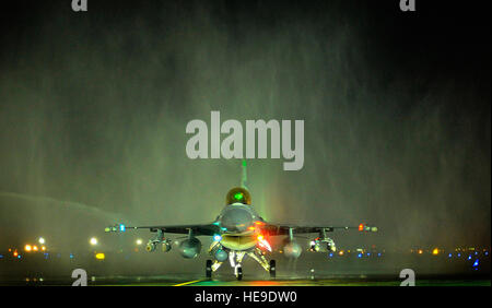 Col. John Dolan, vice Comandante del 332Air Expeditionary Wing, taxi sotto lo spruzzo di due vigili del fuoco crash carrelli 2 Dicembre a base comune Balad, Iraq, dopo aver completato il suo 3,000th battenti ora in un F-16 Fighting Falcon. Circa 150 F-16 piloti hanno superato questa fase cardine. Airman 1. Classe Jason Epley) Foto Stock