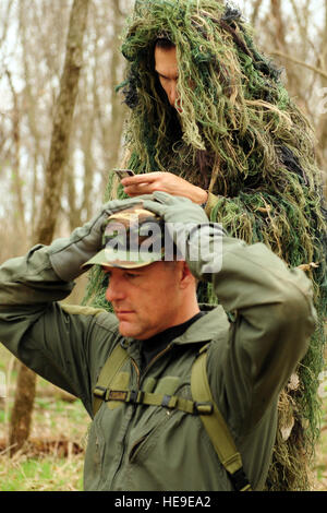 Tech. Sgt. Robert Graham, 375 Operations Support Squadron S.E.R.E specialista verifica l'identità di un equipaggio abbattuto gli stati durante la lotta contro la sopravvivenza di formazione presso l'Illinois esercito nazionale della guardia Sparta Area Formazione, Sparta, Ill. il 22 marzo 2011. Per la sicurezza dei militari che il piano potrebbe crash, essi sono addestrati per igienizzare le loro uniformi, la rimozione di tutti i patch militare, classifica insignias e il nome dei nastri. Il personale Sgt. Teresa M. Jennings) Foto Stock