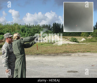 Master Sgt. Bill Kellerman, 482nd Operations Support Squadron equipaggi apparecchiature di volo, incarica il Mag. Julie Moore, 93Fighter Squadron Mako pilota, l'utilizzo di una svasatura gyrojet pistola durante la lotta contro la sopravvivenza della formazione a Homestead Air Base di riserva, Sett. 11. (Inserto: la svasatura sparato da Moore scende verso la terra). La formazione era parte di un evento di due giorni che comprendeva la segnalazione, kit di sopravvivenza familiarizzazione, navigazione terrestre e la terra e l'acqua di formazione di sopravvivenza. (Stati Uniti, illustrazione/ Tech. Sgt. Ian Carrier) Foto Stock