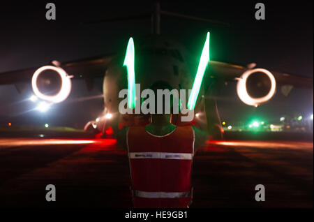 Il personale Sgt. Chris Olmsted, un aeromobile manutentore parte della Joint Task Force-Port team di apertura di emergenza 621st ala risposta assegnato alla base comuneGuire-Dix Mc-Lakehurst, N.J., esegue il marshalling di un C-17 Globemaster III durante il funzionamento Regno assistenza qui, Ottobre 23, 2014. OUA è un U.S. Africa Command-funzionamento led per fornire il comando e il controllo della logistica e della formazione e il supporto tecnico per il governo degli Stati Uniti di sforzi per contenere il virus Ebola focolaio nella zona ovest di nazioni africane. Il personale Sgt. Gustavo Gonzalez/) Foto Stock