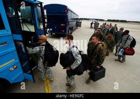 I membri dell'U.S. Esercito, Air Force, Navy e Marines a bordo di un autobus dopo essere arrivati alla base comune Langley-Eustis, Virginia, nov. 13, 2014. Il servizio i membri sono di ritorno dal funzionamento di supporto assistenza unita, un dipartimento della difesa il funzionamento in Liberia per fornire la logistica, la formazione e il supporto tecnico di U.S. Agenzia per lo Sviluppo Internazionale-ha guidato gli sforzi per contenere il virus Ebola epidemia in Africa occidentale. Il personale Sgt. Gustavo Gonzalez/) Foto Stock