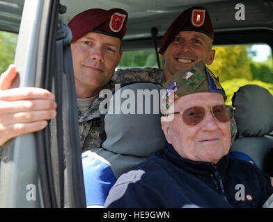 Stati Uniti Paracadutisti dell'esercito con il primo squadrone, 191st reggimento di cavalleria, 173rd Airborne Brigade Combat Team di sedersi con un D-Day veterano in Sainte-M?re-?glise in Normandia, Francia, giugno 4, 2014. La mattina del 4 giugno 1944, le forze alleate hanno condotto una massiccia airborne assalto anfibio e lo sbarco in Normandia Francia. L invasione segnò l inizio della fase finale della II Guerra Mondiale in Europa, che si è conclusa con la resa della Germania nel successivo mese di maggio. Il personale Sgt. Sara Keller Foto Stock