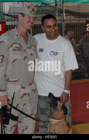 Il comico Russell Peters in posa per una foto con Marina Sottufficiali di terza classe Travis Mouser e suoi militari cane da lavoro a seguito di un uso mostrano a Camp Lemonier, Gibuti, nov. 23, 2007. Peters ha viaggiato con Marine Corps gen. James E. Cartwright, vice presidente del Comune di capi di Stato Maggiore, per visitare le truppe per la festa del Ringraziamento. Tech. Sgt. Adam M. moncone, U.S. Air Force. (Rilasciato) Foto Stock