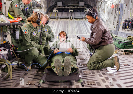 I professionisti medici dalla Air Force della riserva di medicina aeronautica 446th squadrone di evacuazione qui alla base comune Lewis-Mccorda, il trattamento di un paziente nel corso di uno scenario di addestramento su un campo di McChord C-17 Globemaster III aeromobile durante le unità in volo di formazione medica, gennaio 21, 2015. Il 2.100 uomini e donne assegnato alla 446th AW sostenere la mobilità in aria il comando (AMC) missione in tutto il mondo su una base quotidiana, eseguendo il 44 percento di tutti i C-17 missioni lasciando JBLM. (U.S. Air Force Reserve Jake Chappelle) Foto Stock