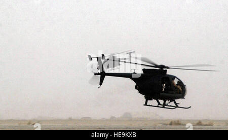 Due US Army (USA) AH-6J Uccellino elicotteri decollare per una missione in corrispondenza di un avanzamento posizione dispiegata in Iraq meridionale durante l'Operazione Iraqi Freedom. Foto Stock